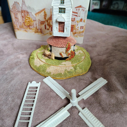 Miniature model of a windmill with a scenic background on a textured surface