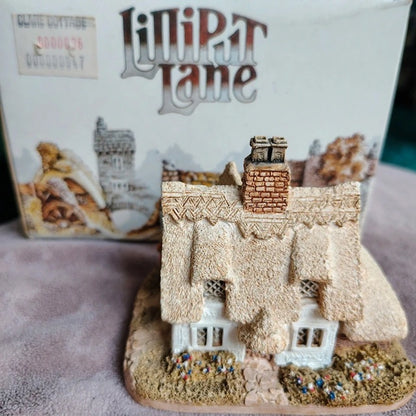 Miniature model of a thatched cottage with 'LiniPat Lane' branding in the background.