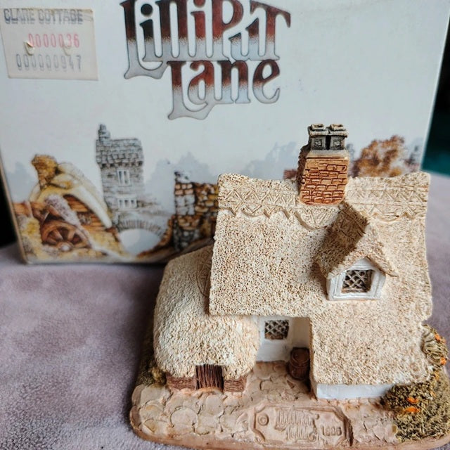 Model of a thatched cottage with 'Llwyn Tan' packaging in the background