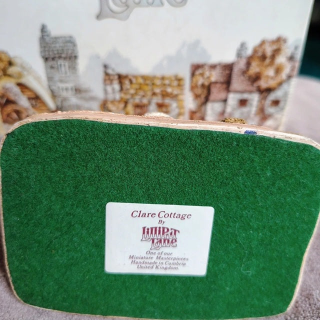 Green pouch with 'Clare Cottage' label on a blurred background