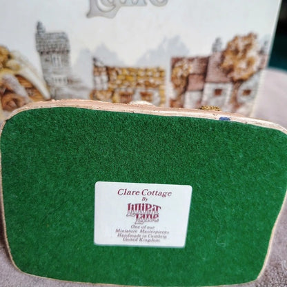 Green pouch with 'Clare Cottage' label on a blurred background