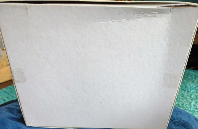White box with a textured surface on a blue fabric background