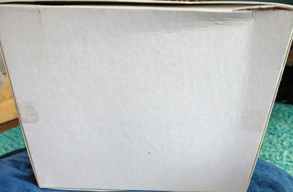 White box with a textured surface on a blue fabric background