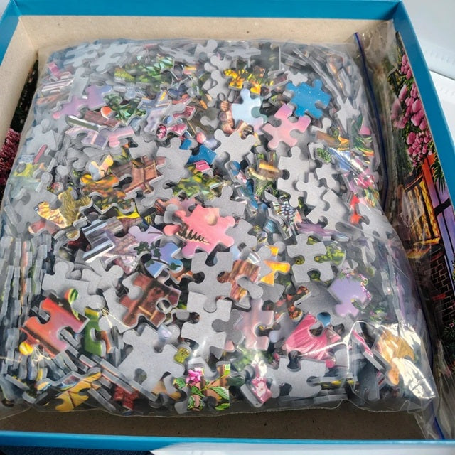 Jigsaw puzzle pieces in a box with colorful puzzle pieces visible