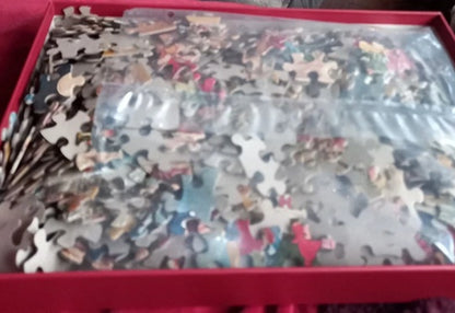 Jigsaw puzzle pieces in a box with a red lid