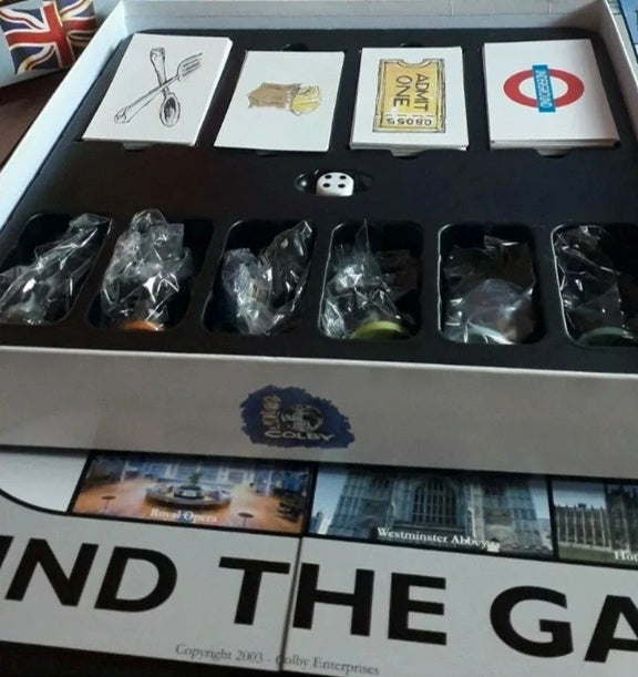 Board game components including cards and dice in a box with 'Find the Gap' branding.