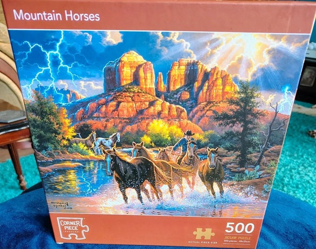 Jigsaw puzzle box featuring mountain horses and a scenic landscape