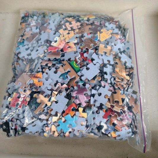 Bag of assorted puzzle pieces on a beige surface