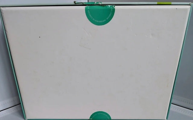 White board with a green sticker on a light gray background