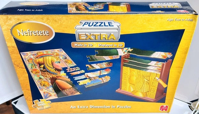 Nefertete Puzzle Extra packaging with illustrations of puzzles and a person in an Egyptian costume.