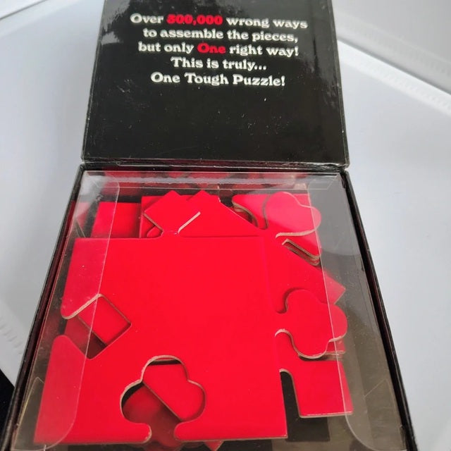 Red puzzle pieces in a box with text about the difficulty of assembly.