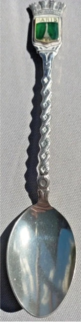 Silver spoon with decorative handle on a gray background