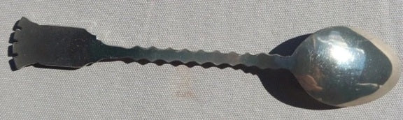 Metallic spoon with a textured handle on a gray background