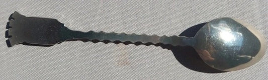Metallic spoon with a textured handle on a gray background