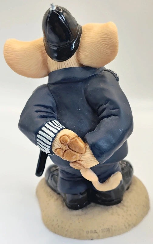 A small figurine of an animal character, resembling a Pig, dressed in a dark navy blue uniform and black helmet, standing on a round beige base against a plain white background.
