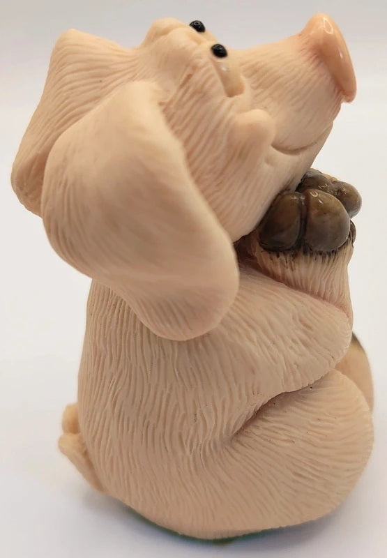 A beige ceramic figurine of a pig, set against a plain white background.