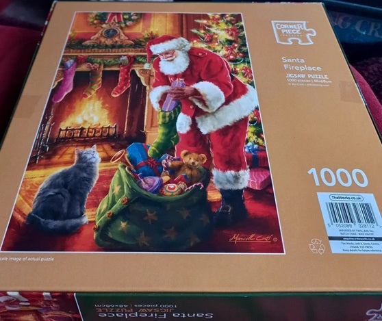 Jigsaw puzzle box featuring Santa Claus and a cat by a fireplace, with 'Cornerstone Puzzles' branding.