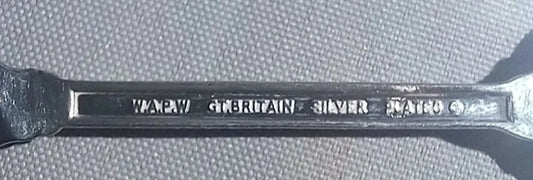 Metal wrench with engraved text on a textured gray background