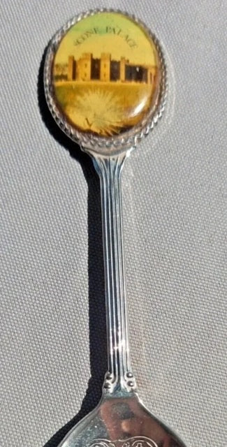 Spoon with decorative handle featuring a scenic design on a plain background