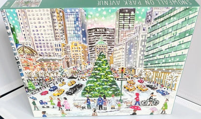 Snowfall On Park Avenue 1000 piece jigsaw puzzle by Galison. Jigsaw puzzle box with a cityscape design featuring a Christmas tree and people.