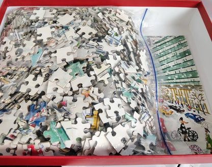 Jigsaw puzzle with pieces scattered on a box, partially completed.