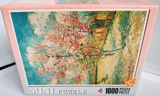 Jigsaw puzzle box with a colorful tree design on a white background