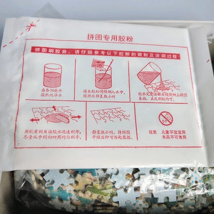 Jigsaw puzzle packaging with glue powder instructions and a partially completed puzzle.