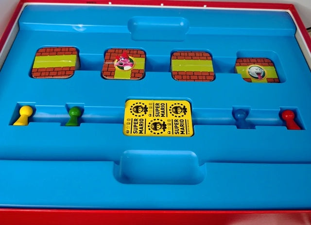 Board game with colorful tiles and a yellow 'Super Mario' card on a blue tray.