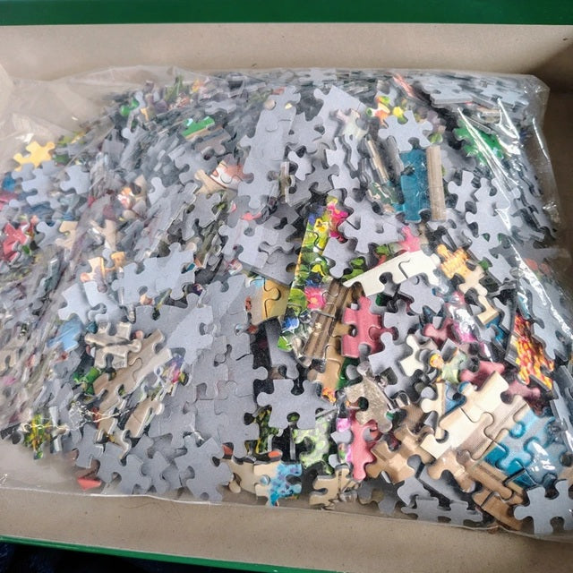 Pile of assorted puzzle pieces in a clear plastic bag.