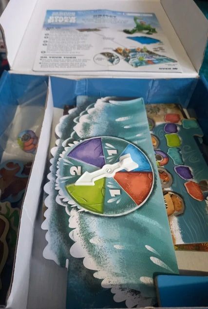 Colorful circular puzzle piece with a box of additional pieces in the background