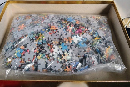 Jigsaw puzzle in a box with some pieces missing, showing a partially completed design.