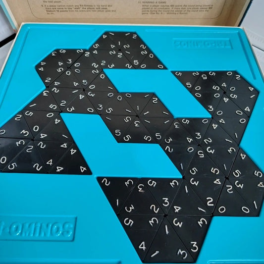 Set of dominoes with numbers on a blue tray, featuring the Domino9 brand.