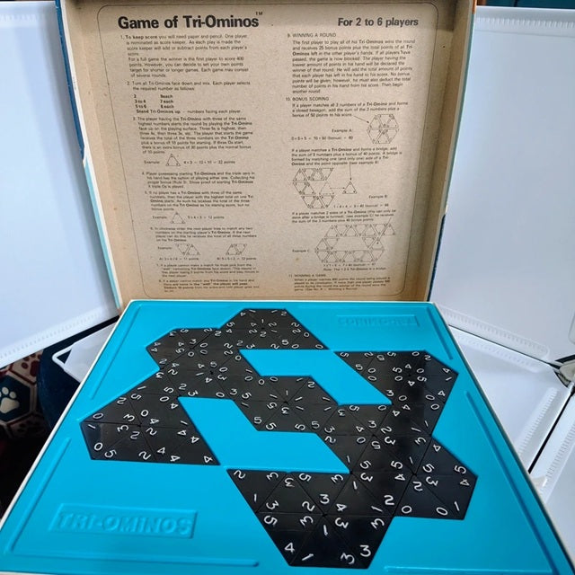 Tri-Ominos game set with pieces and instructions on a blue tray