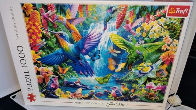 Colourful tropical scene with birds, butterflies and flowers surrounding a waterfall from a 1000 piece puzzle.