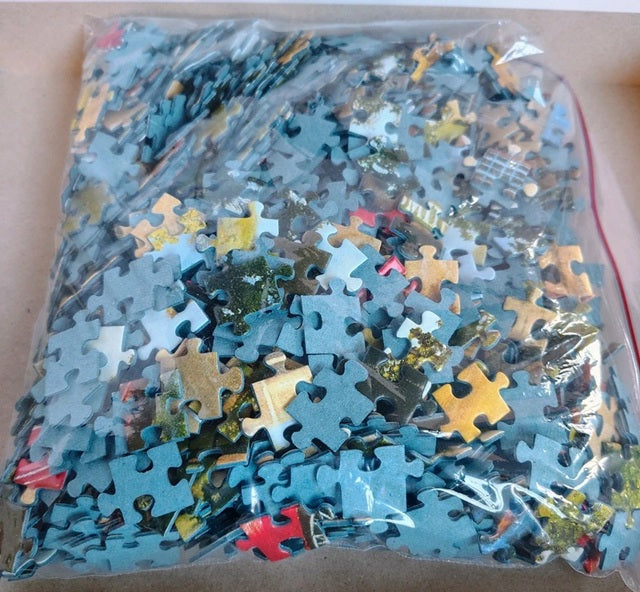 Bag of assorted puzzle pieces with a focus on blue and yellow pieces.