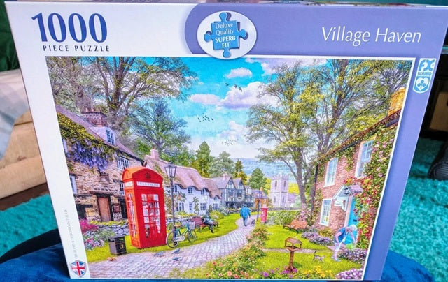 1000 piece puzzle box featuring a village scene with a red phone box.