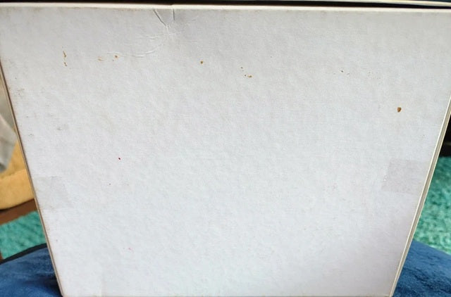Close-up of a textured white surface with small brown spots