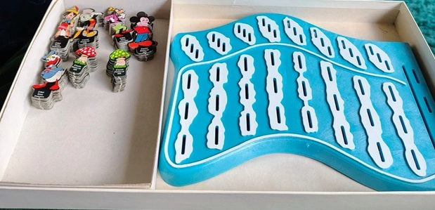 Set of small figurines next to a blue and white plastic mold on a white tray.