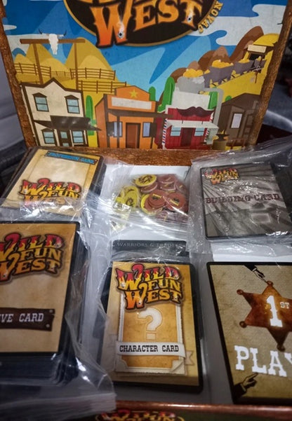 Wild West-themed card game components including cards and a box with a desert town illustration.